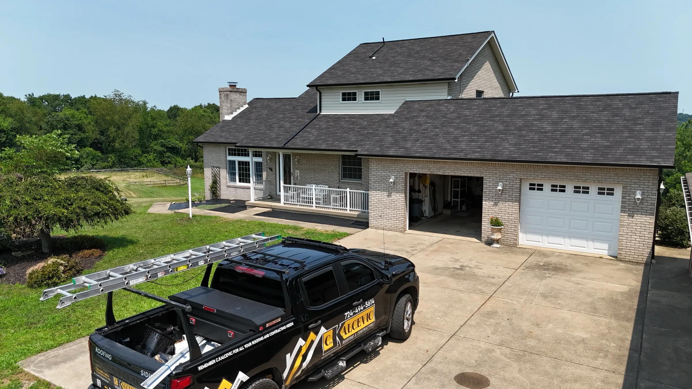 C. Kalcevic Roofing truck parked at a completed roofing job